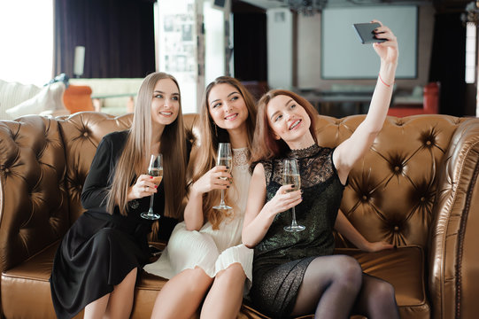 Three young girls are doing selfie photo in a restaurant