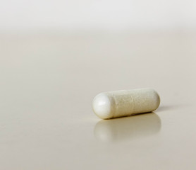 Medicine white capsules on white backgraund.