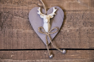 Beige wooden heart with picture of deer on boards