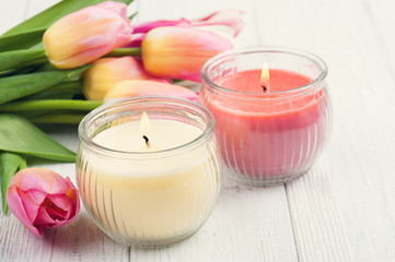 Fototapeta na wymiar Yellow and pink aroma candles with tulips