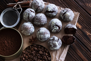 Chocolate cookies on wooden table with coffee bean, cocoa powder, cinnamon and star anise on wooden table.
