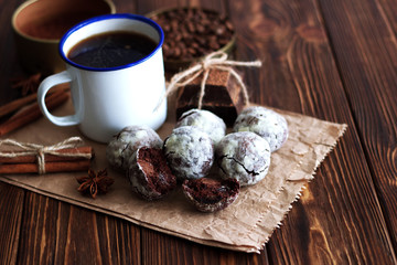 Chocolate cookies and cup of coffee with coffee bean, cocoa powder, cinnamon and star anise on wooden table.