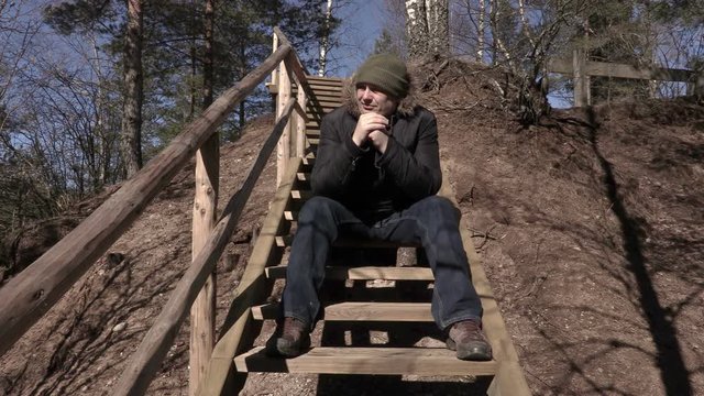 Depressed man sitting on wooden stairs