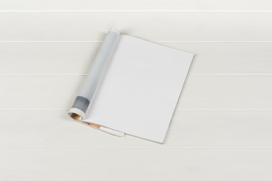 Mock-up magazine or catalog on white wooden table. Blank page or notepad on wood background. Blank page or notepad for mockups or simulations.