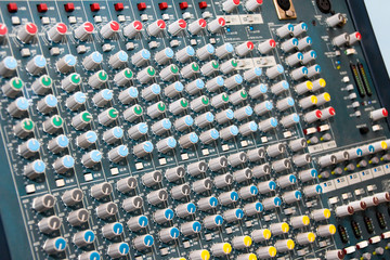 Sound mixing console with lots of buttons and knobs.