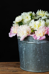 peonies in a metal bucket
