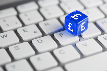 Blau farbener / blauer Würfel mit Währung auf Tastatur - Englisches Pfund