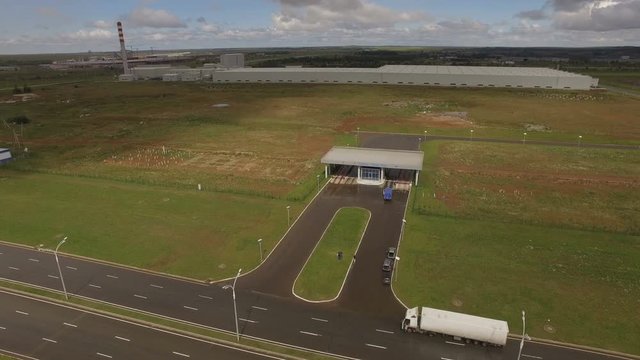 Motion Over Modern Checkpoint and Wet Road against Large Plant