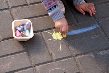 Drawing by pieces of chalk on asphalt in city park