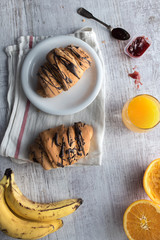 Fresh croissant with chocolate glaze on breakfast