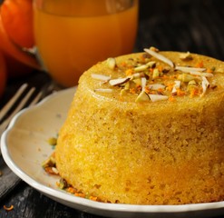 Gluten free Orange blossom cake topped with nuts on dark moody background,selective focus