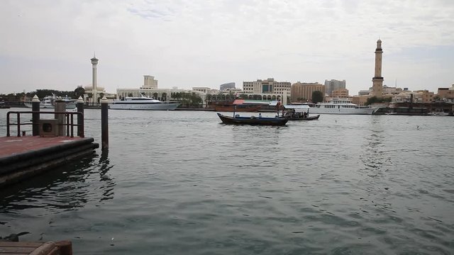 Dubai creek with abras leaving and arriving to the pier. View from Deira to Bur Dubai side.