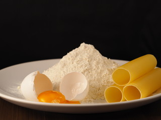 Italian pasta cannelloni with broken egg and flour.


