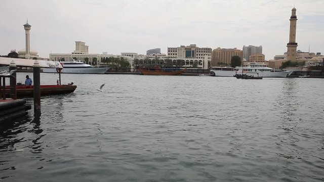 Dubai creek with abras leaving and arriving to the pier. View from Deira to Bur Dubai side.