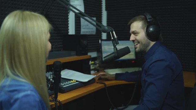 Presenters or moderators - man and woman - in radio station hosting show for radio live in Studio