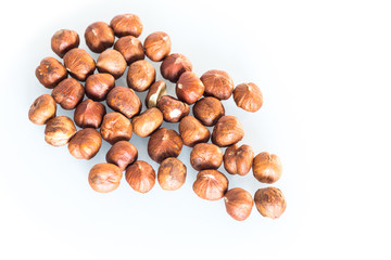 Delicacies hazelnuts scattered on the white background.