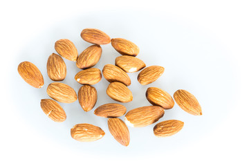 Delicacies almonds scattered on the white background.