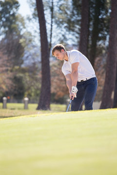 Close up image of a golfer playing a chip shot onto the green on a golf course in south africa.