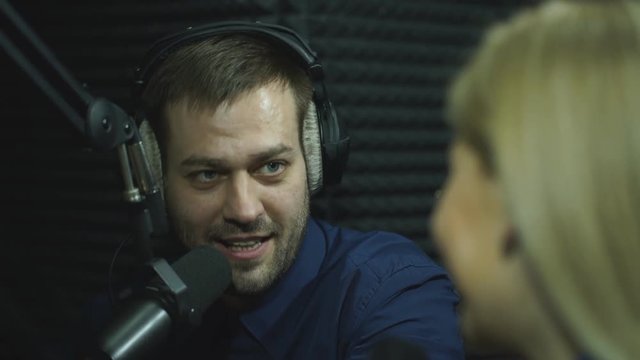 Presenters or moderators - man and woman - in radio station hosting show for radio live in Studio
