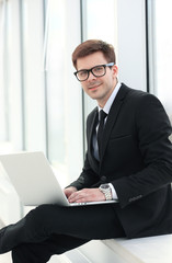 closeup -a successful businessman-blogger with a laptop sitting 