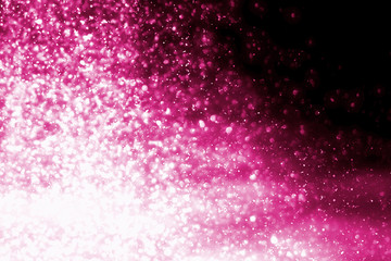 Magic festive pink particles isolated on black background. Bokeh light and sparkles. Abstract glitter lights