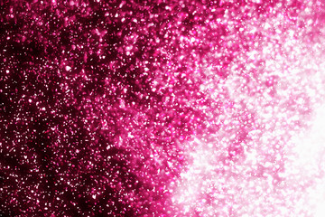 Magic festive pink particles isolated on black background. Bokeh light and sparkles. Abstract glitter lights