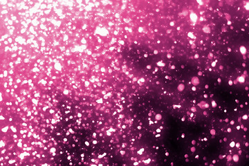 Magic festive pink particles isolated on black background. Bokeh light and sparkles. Abstract glitter lights