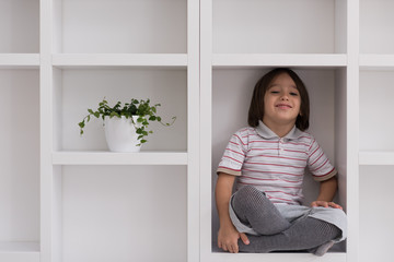 Fototapeta na wymiar young boy posing on a shelf