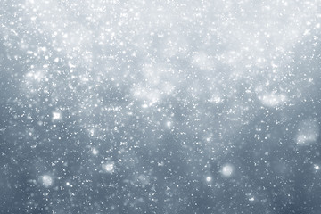 Snowflakes particles and bokeh or glitter lights on silver background. Christmas abstract template