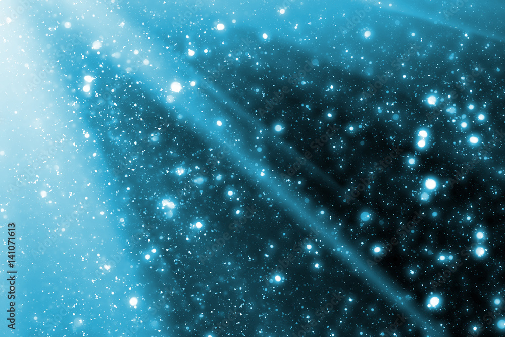 Poster abstract bokeh glitter lights and rays on blue background. round defocused circle particles. christm