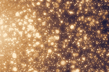 Golden rays and sparkles or glitter lights. Merry Christmas festive background.defocused circle bokeh or particles