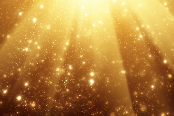 Golden rays and sparkles or glitter lights. Merry Christmas festive background.defocused circle...