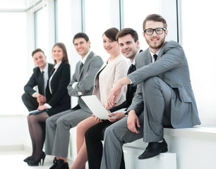 group of University students sitting on the windowsill in the lo