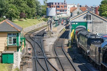 Steam train and carriages with tracks at Swanage railway station