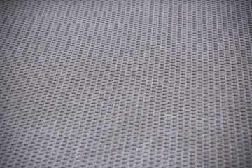 Relief textile background with small squares, shallow depth of field