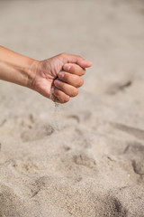 Sand running through female hands.Young woman with sand in her hands. Sand as