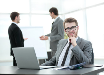 Fototapeta premium successful businessman sitting at the table with an open laptop 
