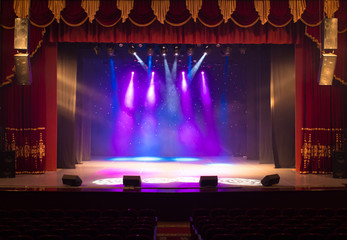 An empty stage of the theater, lit by spotlights and smoke before the performance