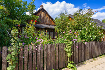 Fototapeta na wymiar Old wooden house with fence and summer flowers in city of Kazimierz Dolny. Poland.