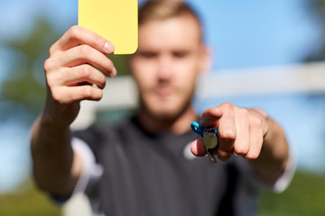 referee on football field showing yellow card - obrazy, fototapety, plakaty