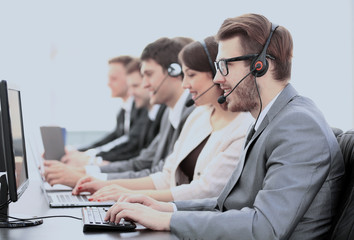 operators with headsets in front of computers in the call center