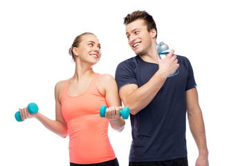 sportive man and woman with dumbbell and water