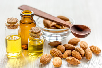 cosmetic and therapeutic almond oil on light wooden background