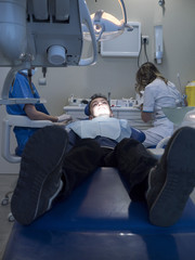 Dentists with a patient during a dental intervention to boy