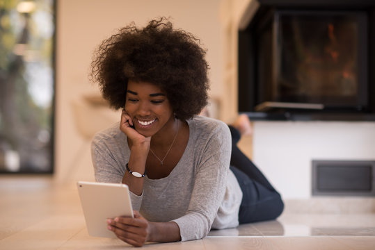 black women using tablet computer on the floor