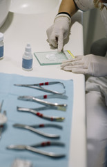 Detail of hand holding dental tools in dental clinic.