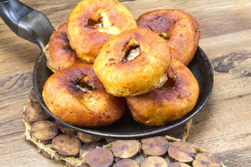 Fried patty on a frying pan with greens and a stand
