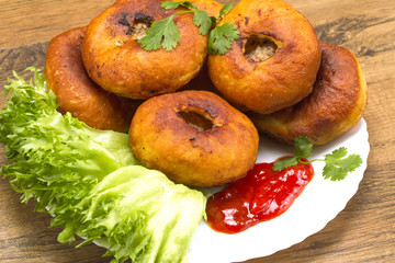 Fried patty on a plate with greens and ketchup