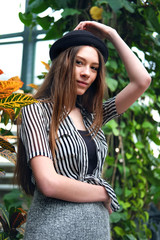 Beautiful long hair girl in hat posing in tropical garden