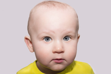 Serious blue-eyed toddler looking at camera